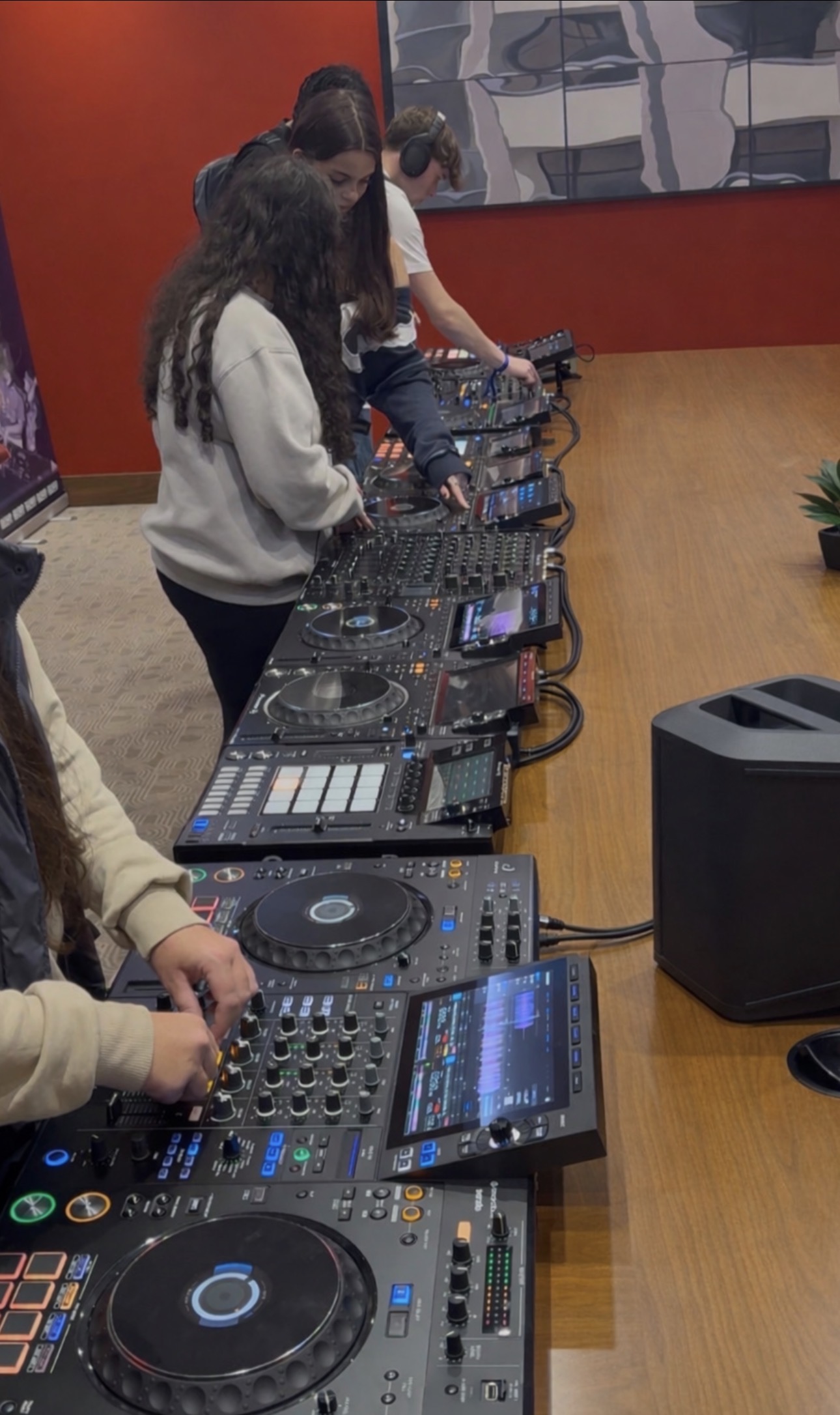 Hands mixing on DJ decks under stage lights