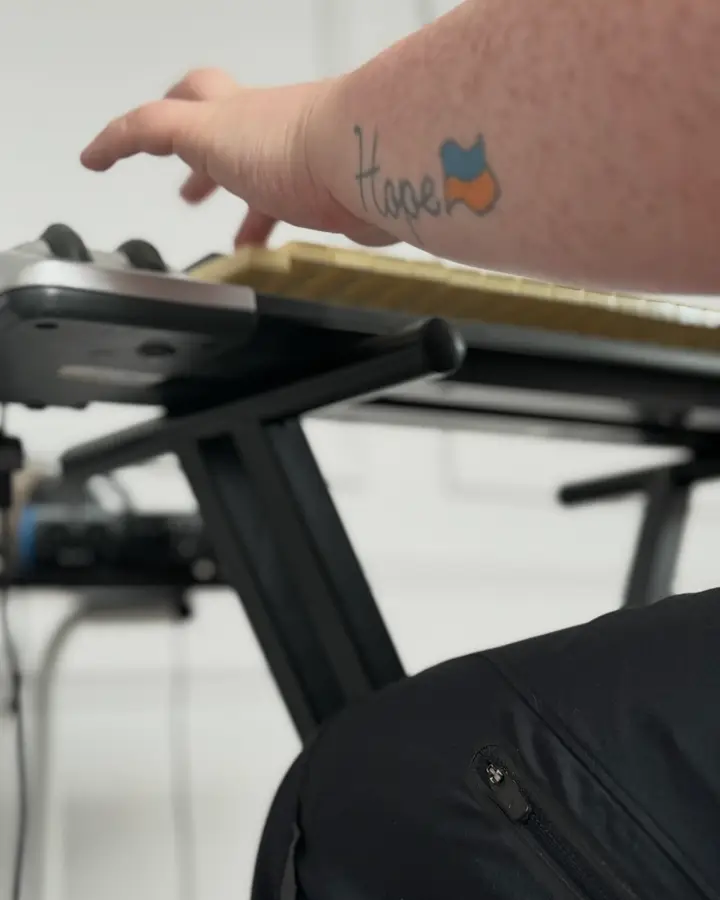 Hand playing a keyboard during a music production session